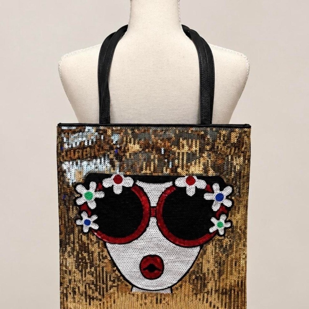 Black tote bag with gold sequin background and a face wearing sunglasses